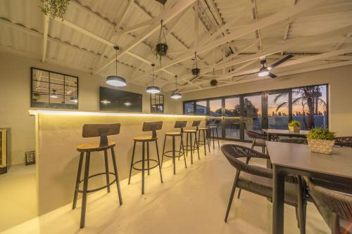 a bar in a restaurant with chairs and tables at Room 4 - LEO Sky Guest House in Simondium