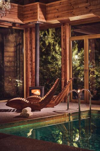 a swimming pool with a fireplace next to a house at domki z dostępem do SPA i restauracji in Łapsze Niżne