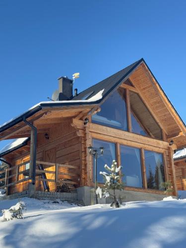 a log cabin in the snow with snow at domki z dostępem do SPA i restauracji in Łapsze Niżne