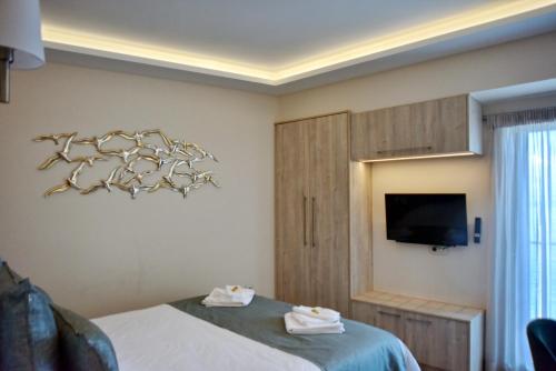 a hotel room with a bed and a tv at Sykea Luxury Apartment in Xylokastro