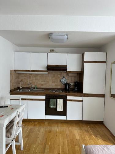 a kitchen with white cabinets and a table in it at Casa pasa - Idylle mit Bergblick in Inzell