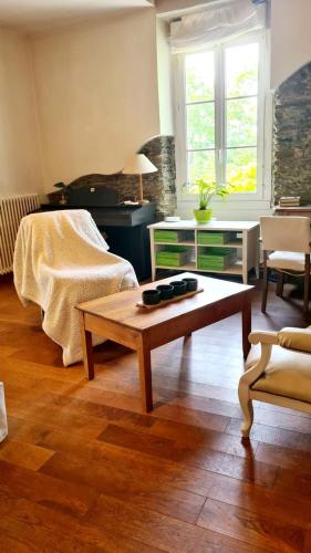 - un salon avec un lit et une table basse dans l'établissement Pierre et rivière - Une terrasse en ville, à Nantes