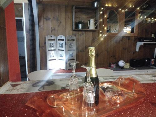 - une bouteille de vin assise sur une table en verre dans l'établissement LOVE ROOM Chalet des ALPES, à Guillestre