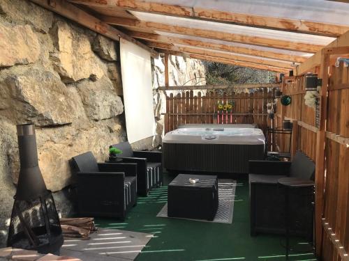 une chambre avec un jacuzzi et des chaises sur un patio dans l'établissement LOVE ROOM Chalet des ALPES, à Guillestre