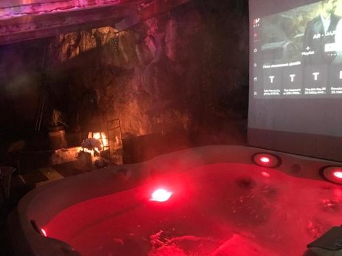 Cette chambre dispose d'une baignoire rouge et d'une télévision. dans l'établissement LOVE ROOM Chalet des ALPES, à Guillestre