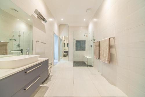 a white bathroom with a sink and a shower at Room 5 - LEO Sky Guest House in Simondium