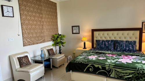 a bedroom with a bed and a chair and a table at Murree - Bhurban Apartment with Private Balcony in Bhurban