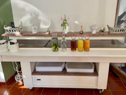 a white table with four glass vases on it at BELYSIUM B&B Wine&Relax Vendégház in Gyenesdiás
