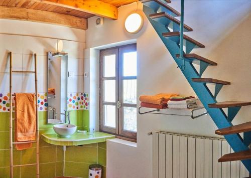 une salle de bain avec un escalier bleu et un lavabo dans l'établissement Entre garrigue et potager bio, à Montségur-sur-Lauzon