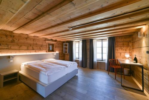 a bedroom with a bed and a wooden ceiling at Hotel Maloja Kulm in Maloja