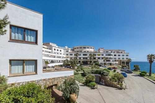 an apartment building with the ocean in the background at Sa Calma - Cap Sa Sal Begur in Isla Negra