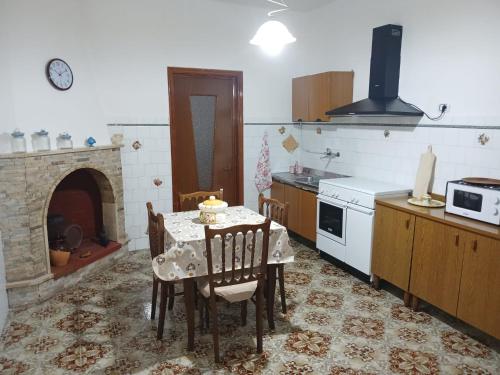 a kitchen with a dining table and a fireplace at Casantina in Maruggio