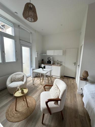 une chambre blanche avec un lit, une table et des chaises dans l'établissement CASA Buenos Aires, à Cholet