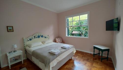 a bedroom with a bed and a window at Sítio Canto das Águas in Petrópolis