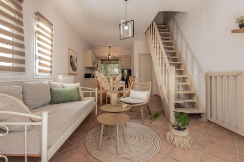 a living room with a couch and a staircase at Alavastros Villa Maisonettes in Vasilikos