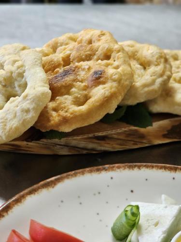 two pies on a cutting board with a plate of food at Hani i Ilirit in Cërrik
