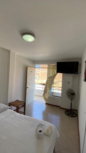 a bedroom with a bed and a flat screen tv at Hospedaje Rio Hotels Mancora in Máncora
