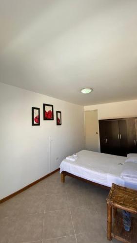 a bedroom with a large white bed and a table at Hospedaje Rio Hotels Mancora in Máncora