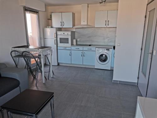 une cuisine avec lave-linge, sèche-linge et une table dans l'établissement Appartement T2 Marina, à La Tour-de-Salvagny