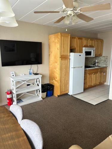 a kitchen with a white refrigerator and a tv at Astronaut Motel in Wildwood Crest