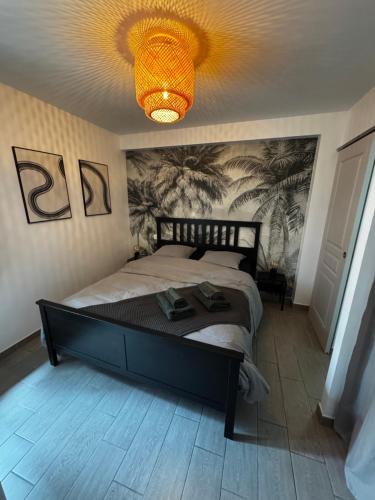 une chambre avec un grand lit et un lustre dans l'établissement La Bastide Saint Pierre T2 - Jardin, à Roquebrune-sur Argens