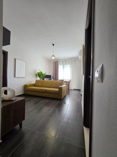 Una sala de estar con un sofá amarillo y una mesa. en Modus Mare Gjiri i Lalzit, en Lalzit Bay