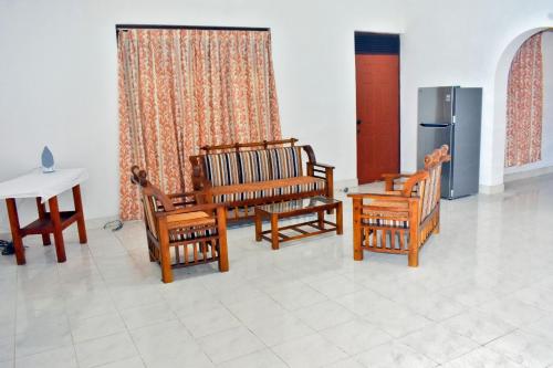a room with chairs and a table and a refrigerator at Peradeniya-Kandy Home Stay in Peradeniya