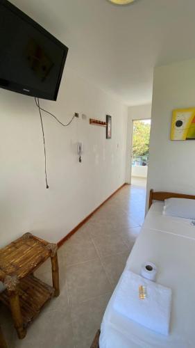 a bedroom with a bed and a tv on the wall at Hospedaje Rio Hotels Mancora in Máncora