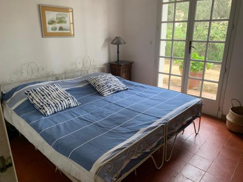 - un lit avec une couette et des oreillers bleus dans une chambre dans l'établissement Beautiful house, sea view, access to beach path 7mn, à Roquebrune-sur Argens