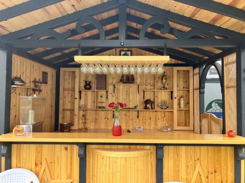 a kitchen with wooden cabinets and a counter with flowers at Golyaka Stone Garden Hotel in Orhangazi