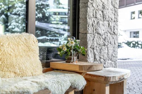 a table and two benches next to a window at Chalet Elisabeth dolomites alpin & charme in Selva di Val Gardena