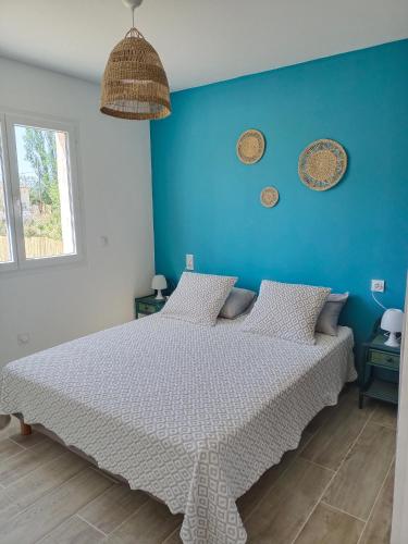 une chambre avec un lit avec un mur bleu dans l'établissement Petite villa Canet d'Aude, à Canet d'Aude