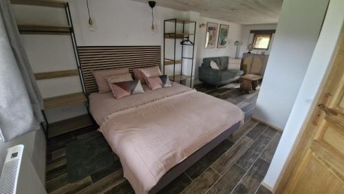 a bedroom with a large bed and a living room at La Maison Rose Bertignat in Bertignat