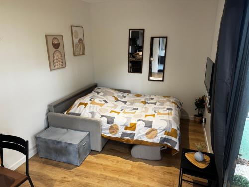 a small bedroom with a bed and a table at Studio paisible sous un Pin près de Disneyland in Montry