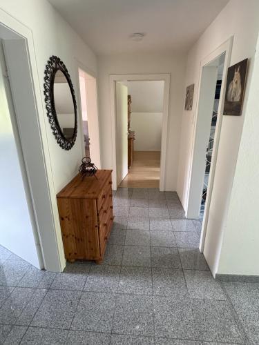 a hallway with a mirror and a wooden dresser at Urlaub im Naturschutzgebiet in Detmold