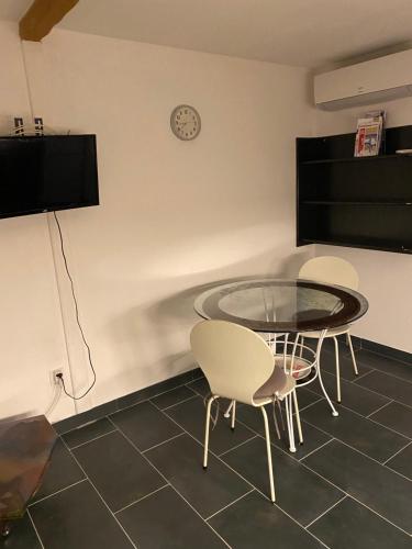 une salle à manger avec une table en verre et deux chaises dans l'établissement Le chant des Cigales, à La Celle-sous-Gouzon