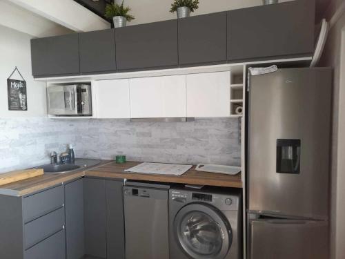 une cuisine avec un réfrigérateur et une machine à laver dans l'établissement Bellevue au cap d agde, au Cap d'Agde