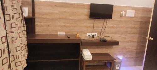 a room with a desk and a television on a wall at Prantik Retreat in Bāgnān