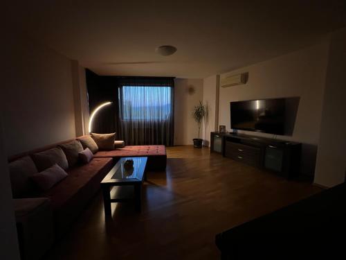 a living room with a couch and a flat screen tv at Pravets Lake Panorama Apartments in Pravets
