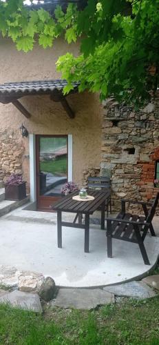 a picnic table and bench in front of a stone building at Albaluna 2 casa vacanza in Dronero