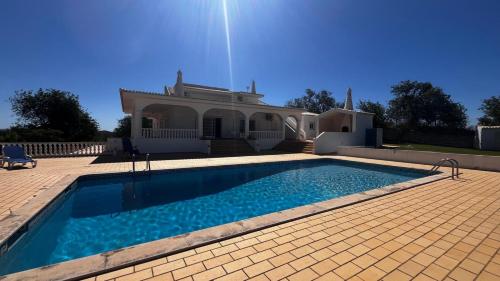 a large swimming pool in front of a house at BnB Homes Luxurious Villa Stardust with Swimming pool & BBQ for Family Fun in Ameijoafas