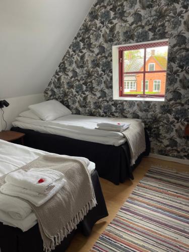 a room with two beds and a window at Peppinge Bed & Breakfast in Löderup