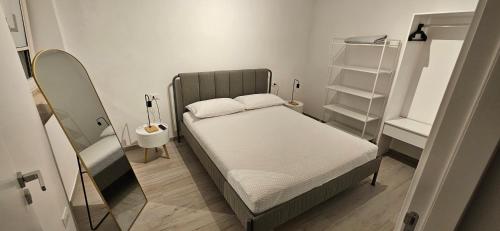 a small bedroom with a bed and a mirror at Canyon House Leuca in Leuca