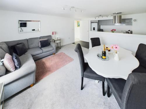 a living room with a couch and a table at A beautiful apartment near all amenities in Ottery Saint Mary