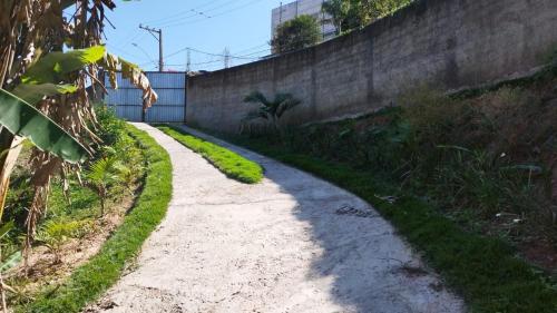 a dirt road next to a retaining wall at Espaço da Família hospedagem Mairiporã in Mairiporã