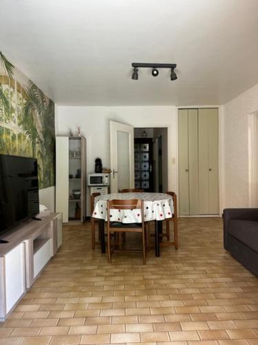 un salon avec une table et une télévision dans l'établissement Appartement proche plage, à La Londe-les-Maures