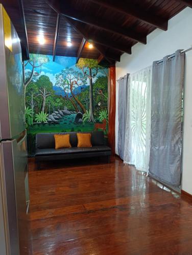 a living room with a couch in front of a mural at Villas Kiki in Puerto Viejo