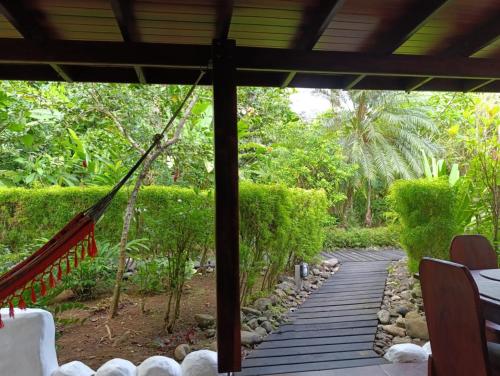 a porch with a hammock in a forest at Villas Kiki in Puerto Viejo