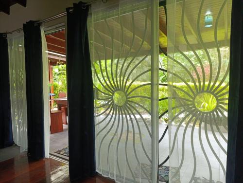 a glass door with two suns on it at Villas Kiki in Puerto Viejo