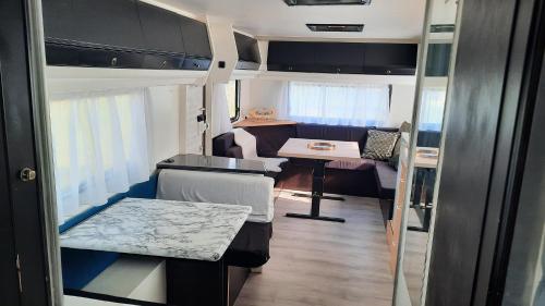 a small kitchen and living room in an rv at Caravan De Rozenbottel in Hensbroek